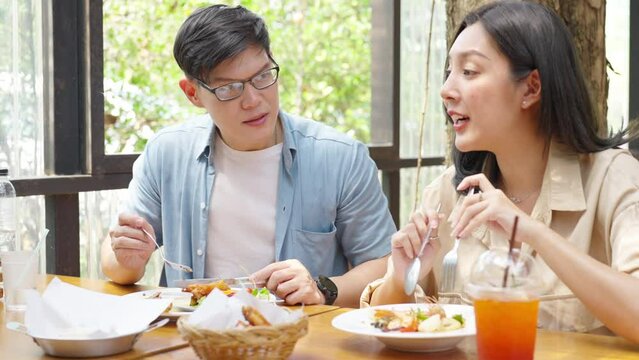 4K Happy Asian couple and elderly father having lunch eating meal together at cafe restaurant on summer holiday vacation. Family relationship, father's day and old senior people health care concept.