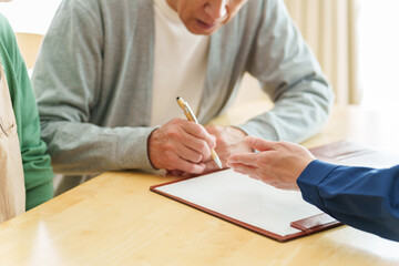 契約書にサインをするシニア男性