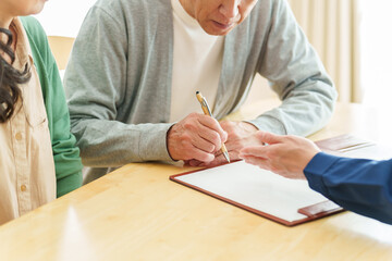 契約書にサインをするシニア男性