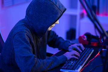 Short of computer hacker wearing white mask stealing data from a laptop. 