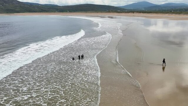 Aerial video of a family having fun on the Beautiful Tullagh Strands Sandy Beach on the Atlantic Ocean in County Donegal Ireland 08-08-23