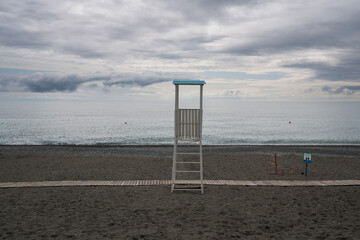A deserted beach on the coast of Sochi and a rescue tower against the background of a cloudy sky...