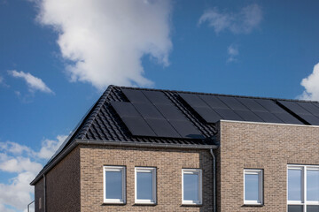 Fototapeta na wymiar Newly build houses with solar panels attached on the roof against a sunny sky in the Netherlands