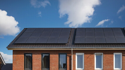 Newly build houses with solar panels attached on the roof Close up of new building with black solar...