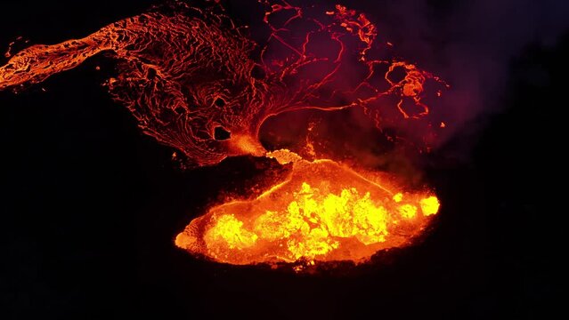 Aerial overview of a erupting lava caldera, night in Iceland - high angle, orbit, drone shot