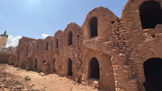 Ksar Hadada granary ruins with mosque in background in Tunisia. Panning