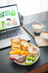 Breakfast toast with cheese and tomatoes, fruit, yogurt, coffee.