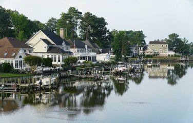 Fototapeta na wymiar The view of the luxury waterfront homes with boat lifts by the bay near Rehoboth Beach, Delaware, U.S.A