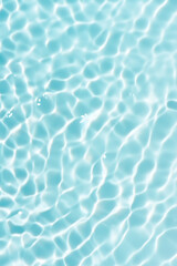 Blue water with ripples on the surface. Defocus blurred transparent blue colored clear calm water surface texture with splashes and bubbles. Water waves with shining pattern texture background.