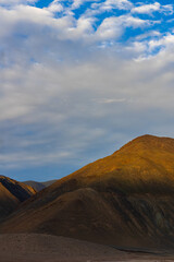 A painting like landscape of brown hills, mountains and blue-sky at Ladakh