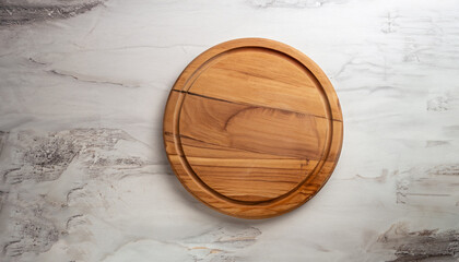 Empty wooden round board on white stone kitchen table, top view, flat lay. Wooden pizza platter,...
