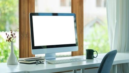 Comfortable home office. Computer, stationery and potted plant on white table..