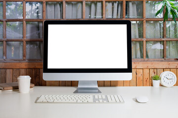 Home office interior with blank computer monitor and office supplies on white table.