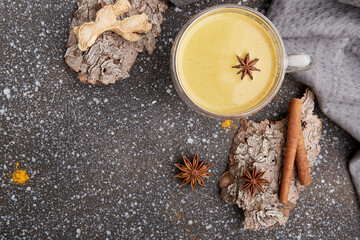 Organic masala tea with star anise, cinnamon, turmeric spices on tree bark. Healthy traditional...