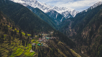 aerial view of Grahan Village - India's Most Beautiful and Hidden village at Himalayas mountains surrounded by snow mountain - Kasol, India