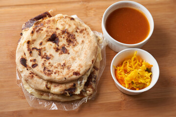 Central America traditional pupusas, a flavorful delight from El Salvador, Honduras, and Nicaragua, served with curtido and sauce on a rustic wooden tray