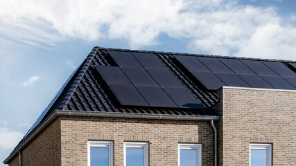 Newly build houses with solar panels attached on the roof, Photovoltaic panels on the roof. Roof Of Solar Panels. View of solar panels solar cell