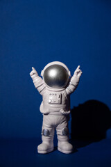 Plastic toy astronaut on colorful blue background Copy space. Concept of out of earth travel,...