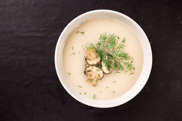 Homemade mushroom soup in a bowl on a dark background.