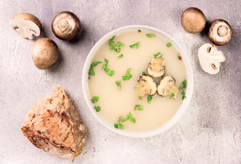 Homemade mushroom soup in a bowl on a gray background.
