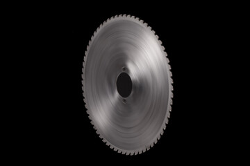 Massive spinning circular saw blade isolated on black background
