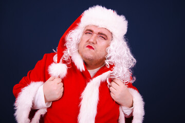 Christmas and New Year. Funny Drag Queen dressed as Santa Coat posing with different emotions on a blue background.