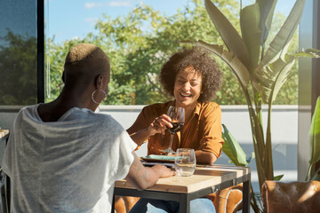 Multiethnic women drinking wine in restaurant