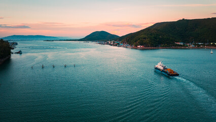 Panoramic aerial view of a industrial cargo container ship traveling over calm, open sea with copy...