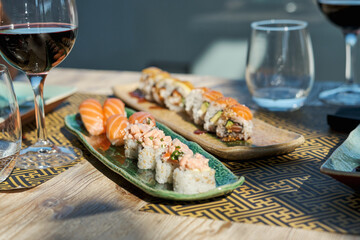 Served plate with fresh sushi and glass of wine