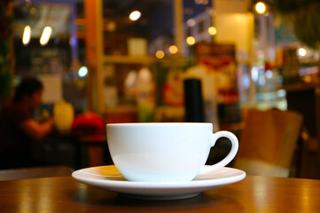 Closeup of a cup of coffee on the cafe wooden table