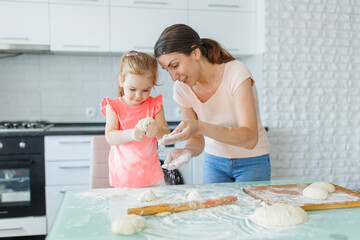 The kitchen becomes a hub of family joy as a mother and daughter prepare dough together, 