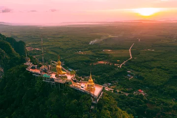 Fotobehang Beautiful aerial drone view of buddha statue on top of the mountain at sunrise, Wat Tham Sua (Seua) or (Tiger Cave Temple), Krabi, Thailand. © Jitti