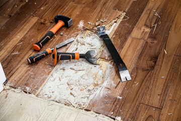 rénovation d'une maison ; enlever un parquet collé avec des outils pour refaire le sol