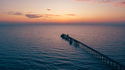 Fototapeta premium aerial drone view of oil jetty at morning sunrise over the sea in the east of Thailand.
