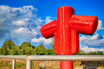 View of Styled Red Fire Cock Hydrant Against of Blue Sky On The Street Of City.