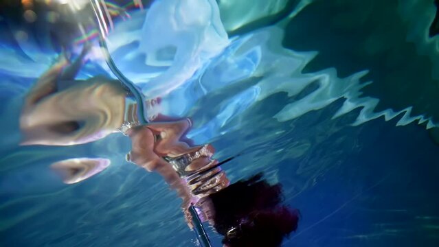 sexy brunette woman diving in depth of swimming pool or aquarium for underwater shooting