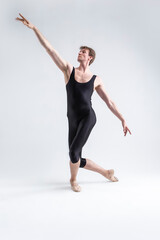 Fototapeta na wymiar Sports Ideas. Young Athletic Caucasian Ballet Dancer Man Posing in Stretching Pose With Hands Aligned and Knees Bended in Black Tights On White.