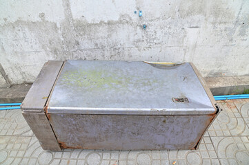 Closeup of Very Old Refrigerator lie down on the floor of the corridor near the wall at Thailand.