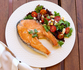 Fried salmon steak with salad