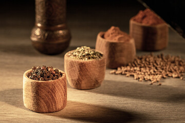 Wooden cups with various spices on a wooden peasant table