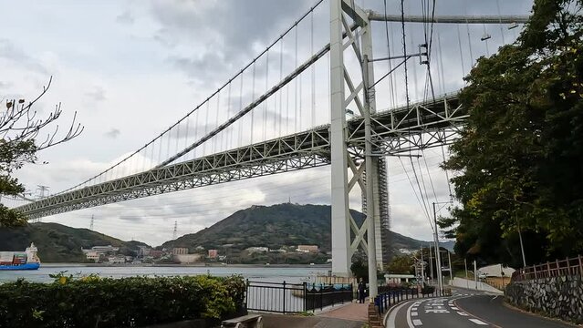 Approaching the  Kanmon bridge and the kanmon strait in between the japanese island Honshu and Kyushu. opening shot