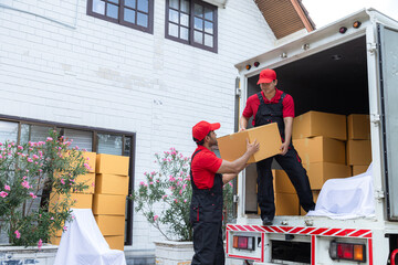 Professional house moving employees worker in uniform work uploading furniture to cargo truck to new house, teamwork Indian man and Caucasian delivery moving house services logistic business industry