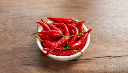 Fotobehang Red malagueta chili peppers on a bowl over wooden table. © Uuganbayar