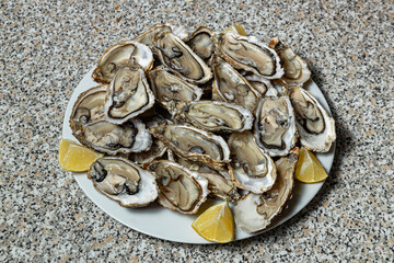 Oysters with lemon on a dish ready for consumption.
