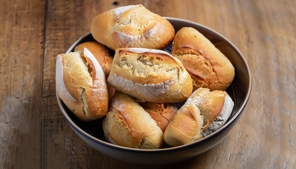 French bread, salt bread or pistolet in a bowl over wooden table.