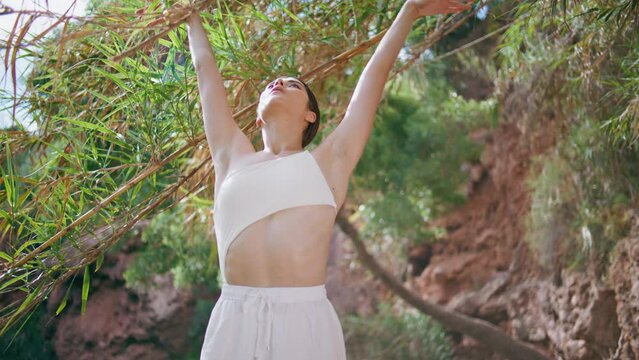 Meditative lady breathing exercises on exotic jungle nature. Woman stretching
