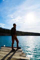 Silhouette of a man against the sky and blue water