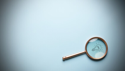 Light bulb inside of magnifier glass for focus business objective target search concept and success...