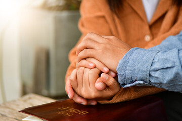 Couple are pray together, hands in prayer together over an open Holy Bible. Christian life crisis...