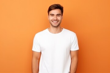 Man wearing white blank t-shirt on orange background, t-shirt template, mockup, studio shot